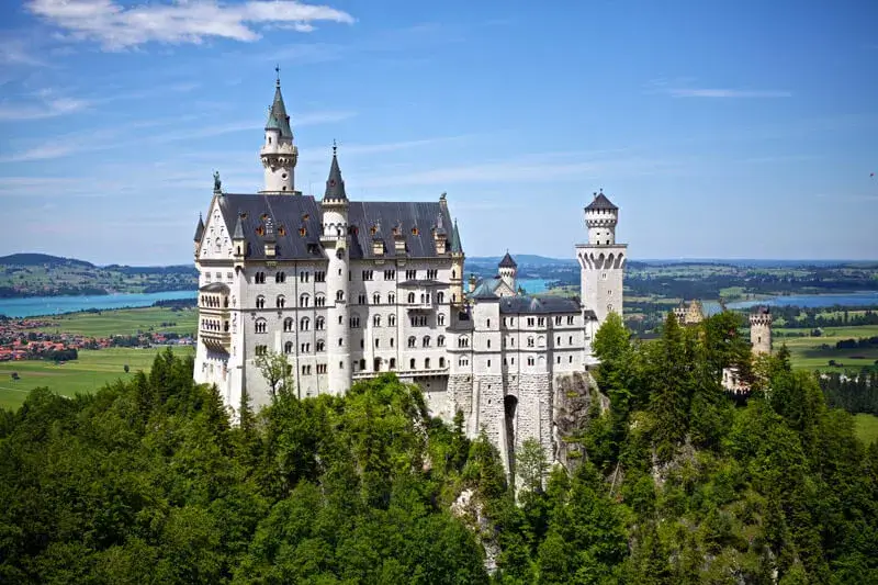 Neuschwanstein Fairy Tale Castle Neuschwanstein Castle up on a cliff in front of an Alpine lake
